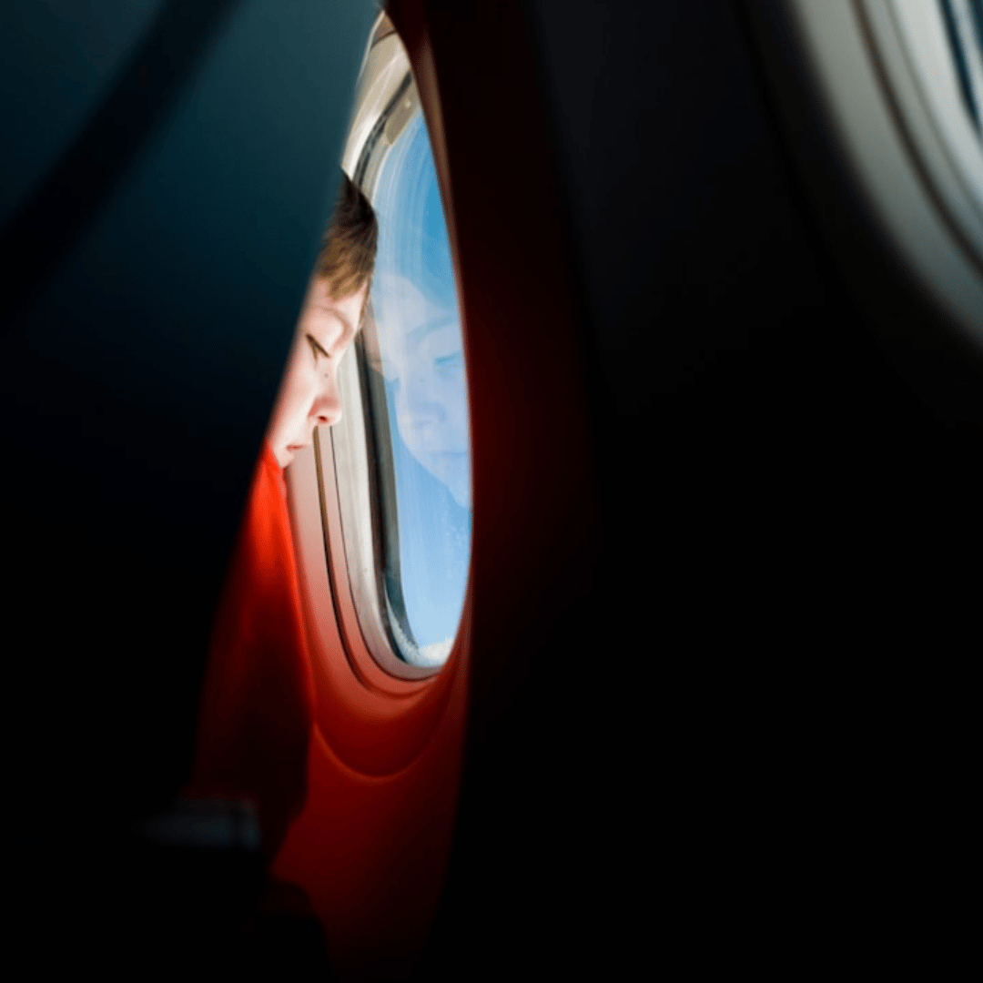 A young child holding a passport and boarding pass, representing the concept of a minor traveling alone.