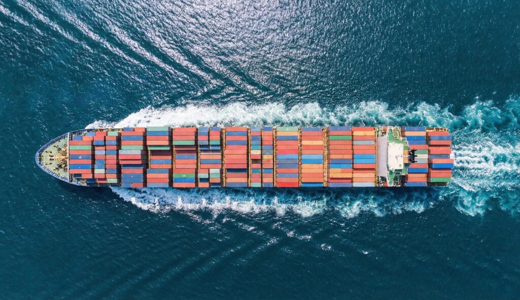 Aerial view of a cargo container ship at sea representing UK export trade. NotaryPublic24 provides online Notarization and Apostille services for Certificate of Free Sale documents required for international export.
