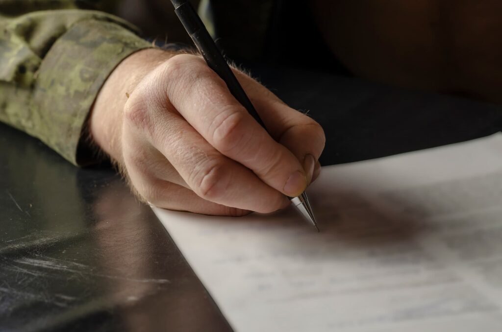 Military service member signing a legal document for power of attorney before deployment – secure notarization and Apostille with NotaryPublic24.