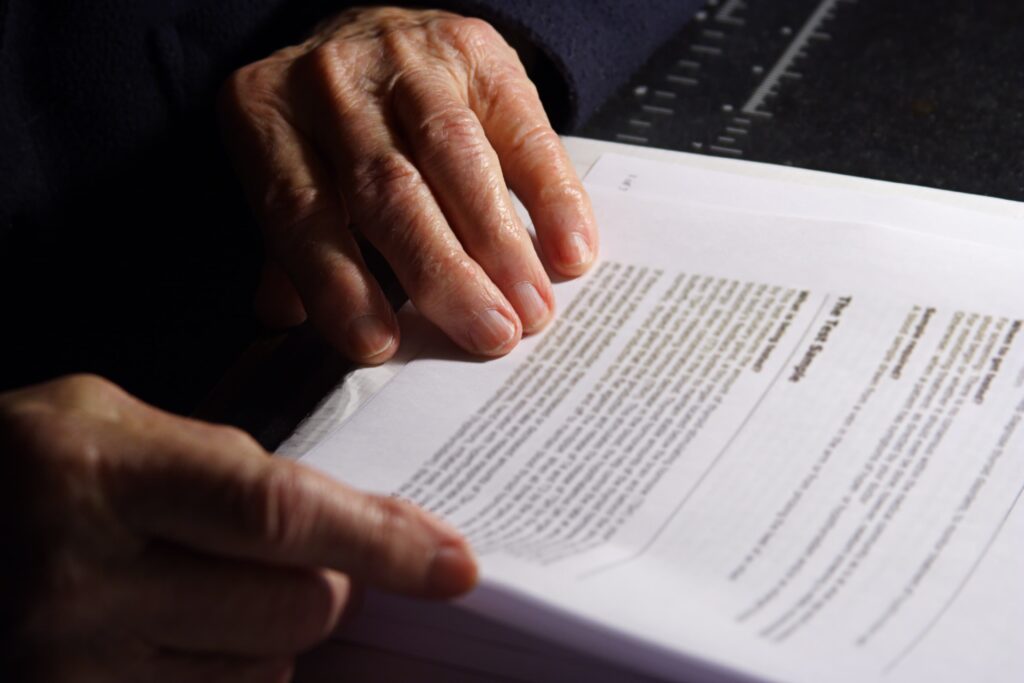 Elderly person reviewing and signing legal documents – concept of getting a Power of Attorney for elderly parent with guidance and notarization through NotaryPublic24.